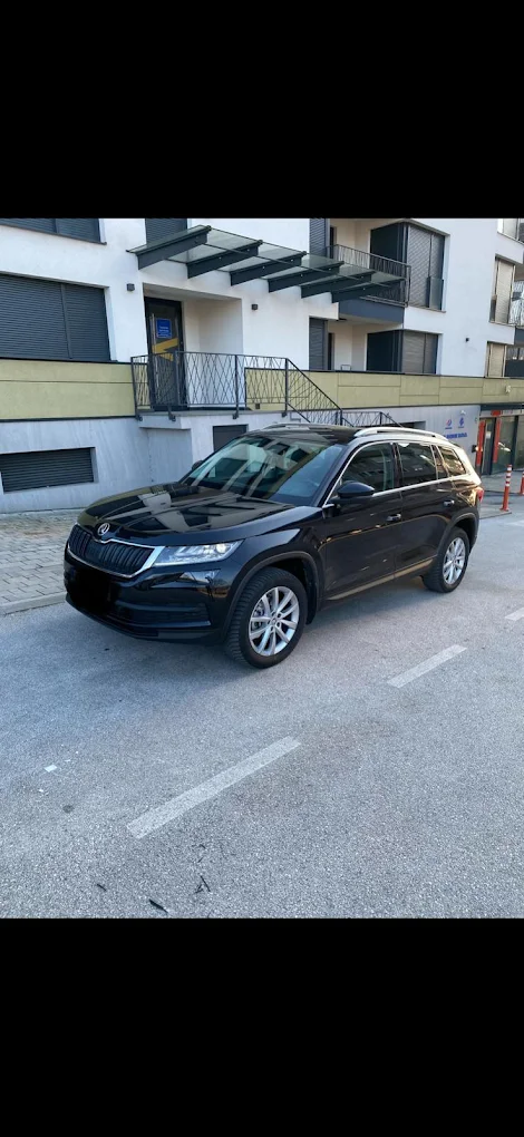 Crna Škoda Kodiaq SUV parkirana pred zgradom u Sarajevu